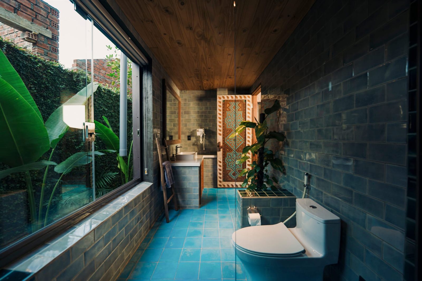 Bathroom with blue tiles and a garden window