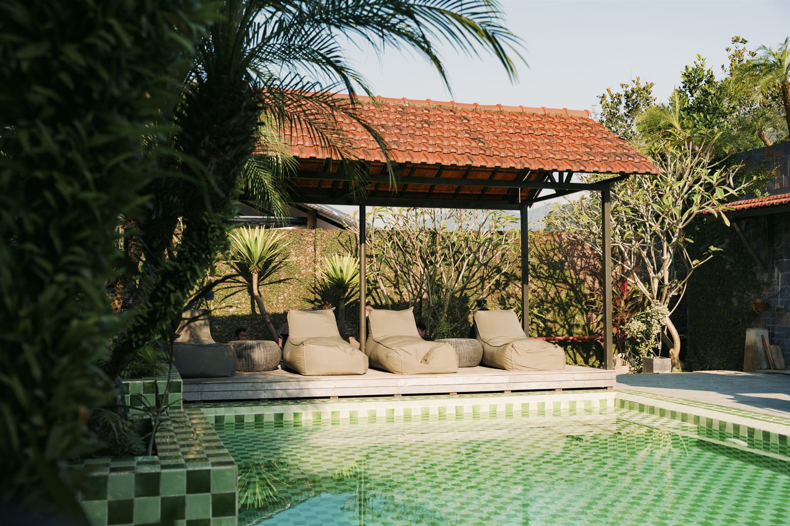 Loungers under a pergola beside the pool