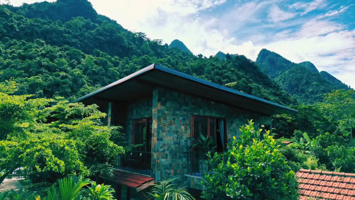 A stone building with karst peaks rising straight up behind it
